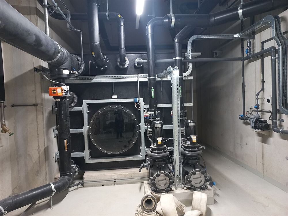 Casa de máquinas de uma piscina com bombas, tubulações e o pré-filtro de uma bomba