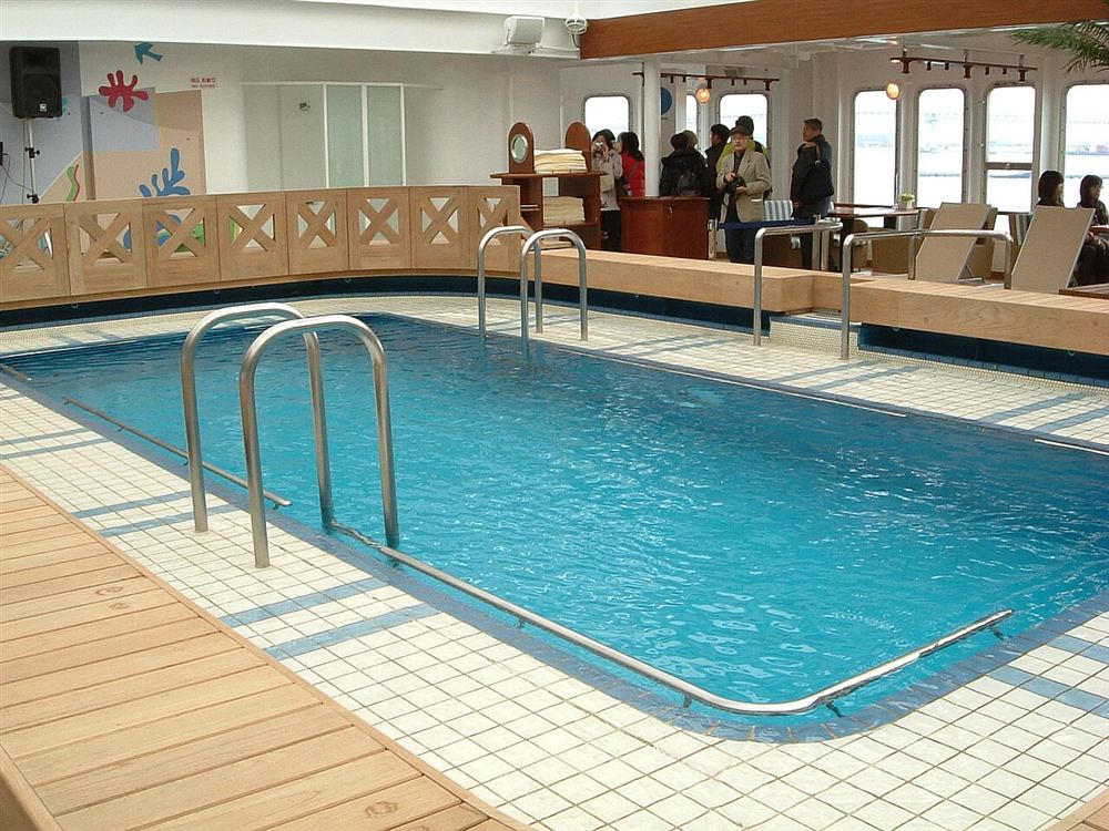 Piscina coberta com escadas de inox e borda de azulejos claros