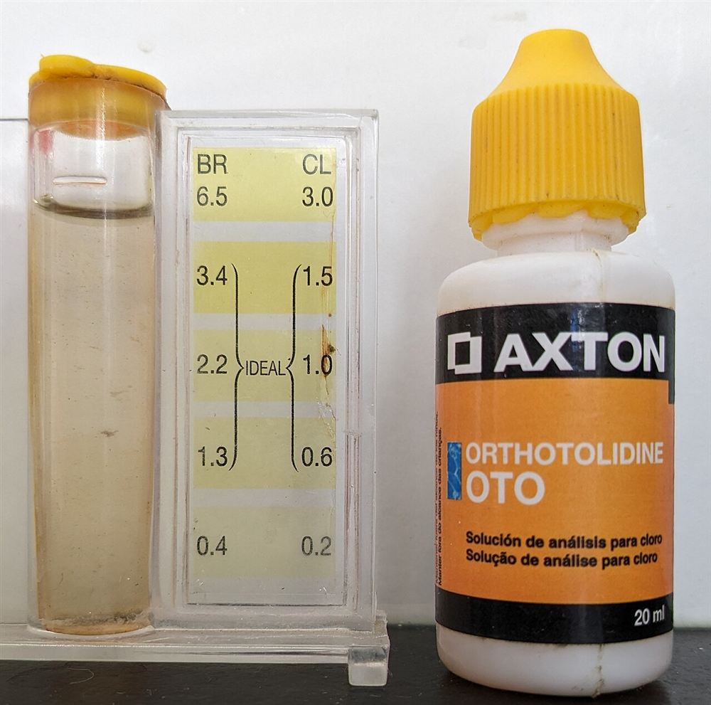 Tubo de comparação de um kit de teste de cloro e pH ao lado do frasco de reagente ortotolidina