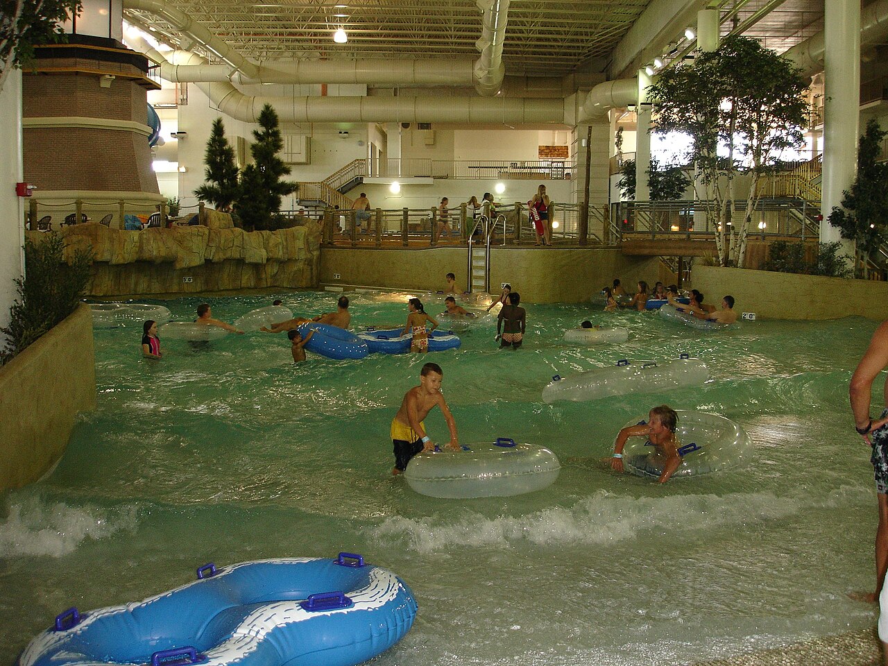 Piscina de ondas coberta num parque aquático, com banhistas e boias