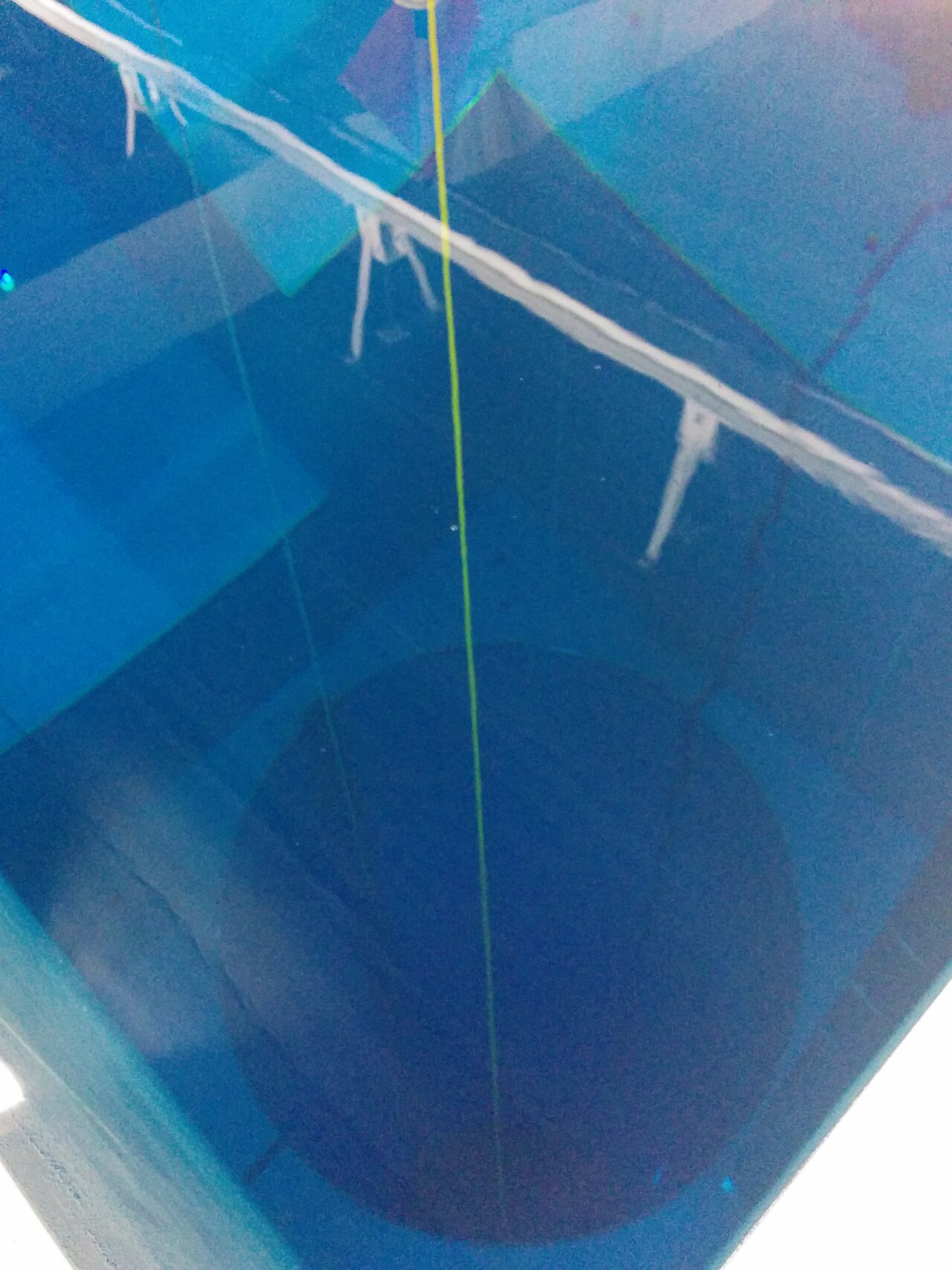 Vista de cima do poço da piscina Y-40, com a água azul descendo em forma de funil