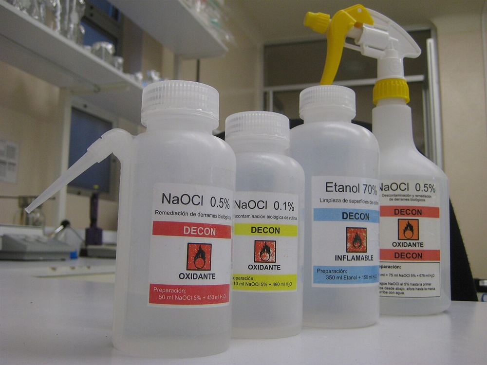 Frascos de laboratório com solução de hipoclorito de sódio e rótulo de oxidante